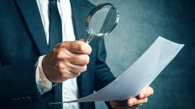 Inspecting law document with magnifying glass